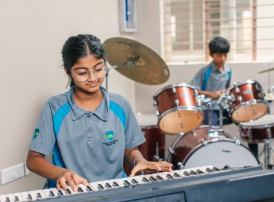 Students at an IGCSE school in Bangalore participating in a music class, playing keyboard and drums