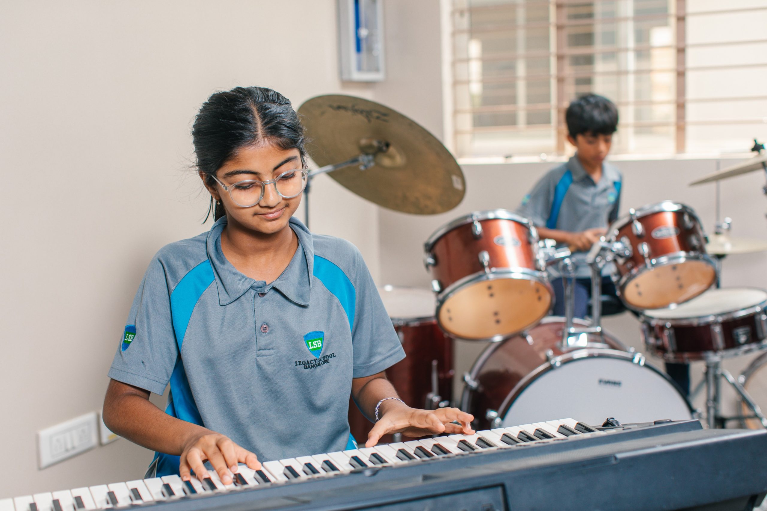 Students at an IGCSE school in Bangalore participating in a music class, playing keyboard and drums